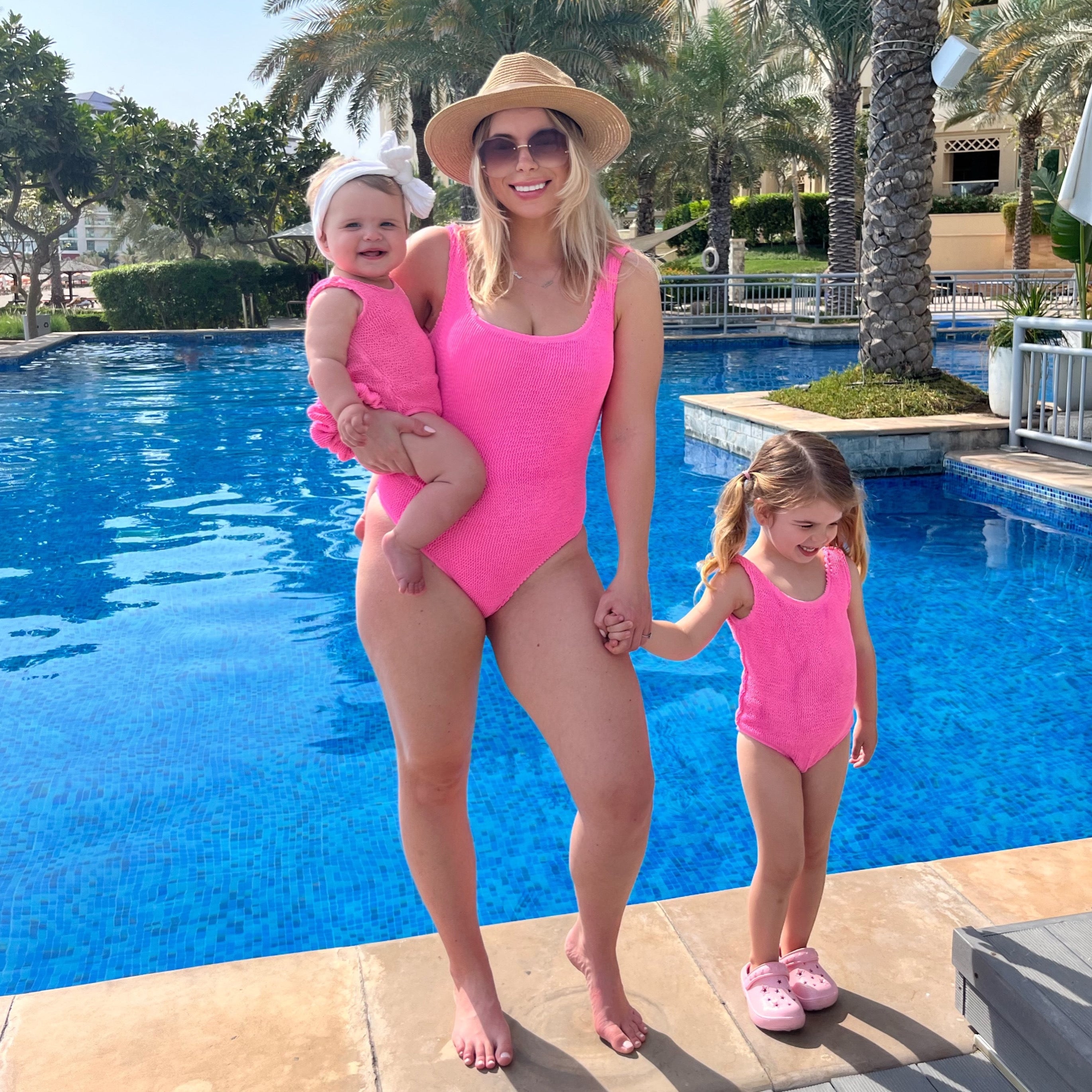 Mum and daughter matching in pink crinkle swimsuits on holiday