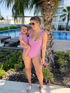 Mum and daughter wearing matching Aura purple swimsuits