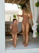 Muse Crinkle Swimsuit in mocha and Muse Kids Crinkle Swimsuit in mocha, matching mum & daughter swimsuits, premium crinkle fabric, square neck and scoop back, by the beach