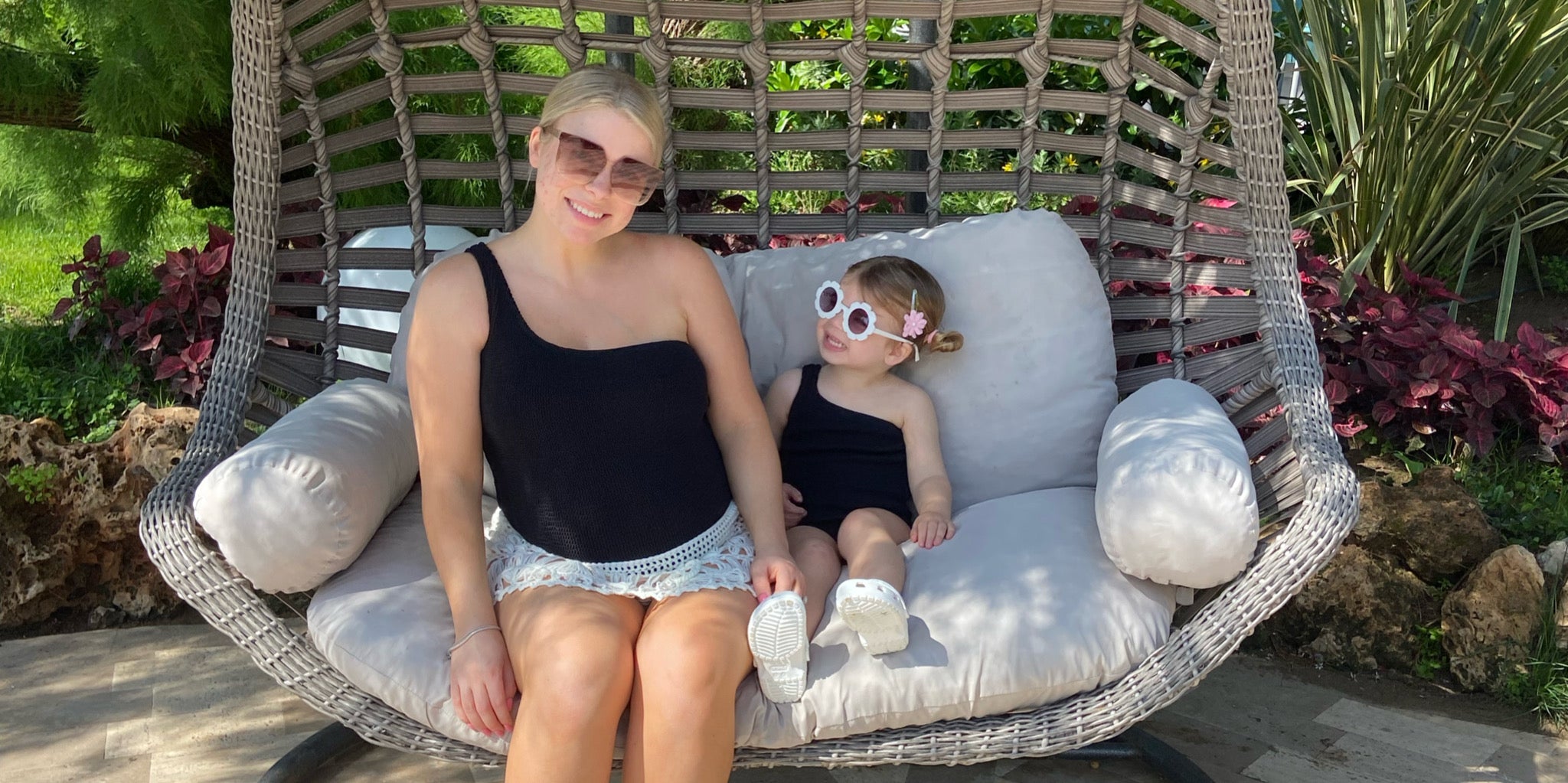 Mum and daughter in The One Strap black crinkle swimsuits on holiday