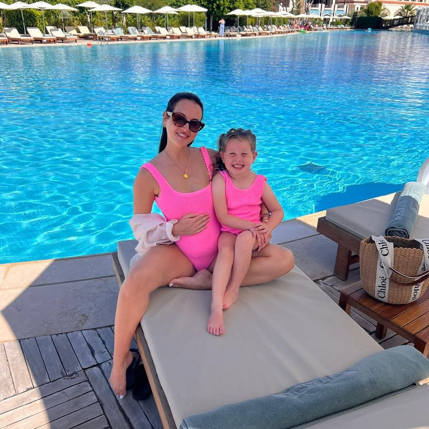 Mum and daughter wearing pink matching crinkle swimsuits on holiday